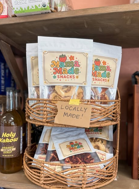 Mama Made Snacks bags displayed on a store shelf beside other snack brands